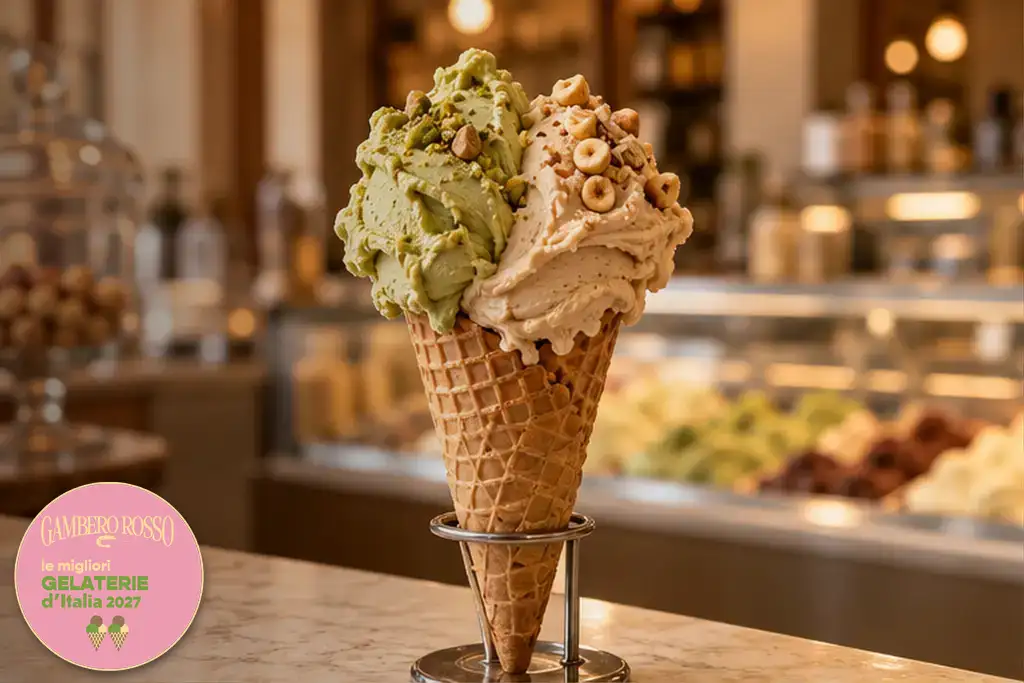 Cono con due gusti di gelato e bollino Gambero Rosso, le migliori gelaterie d’Italia 2027